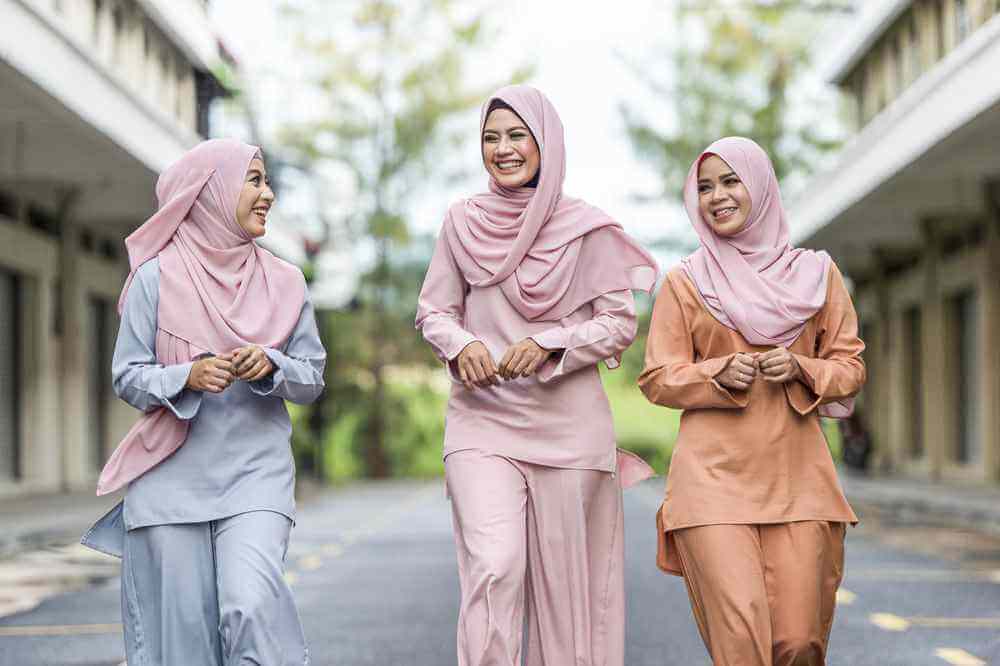tiga wanita memakai hijab sedang bahagia